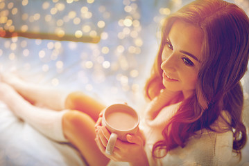 Image showing happy woman with cup of cocoa in bed at home