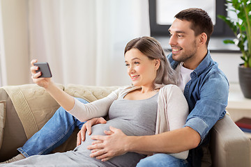 Image showing man and pregnant woman taking selfie at home