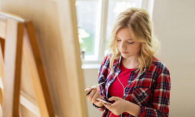 Image showing teenage girl with smartphone at art school studio