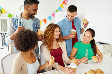 Image showing happy friends or team eating at office party