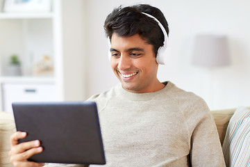 Image showing man in phones with tablet pc listening to music