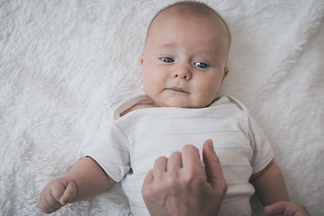 Image showing mom dresses the baby on the bed