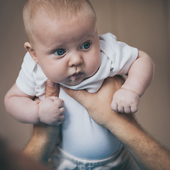 Image showing Father and baby son  playing on the bed.