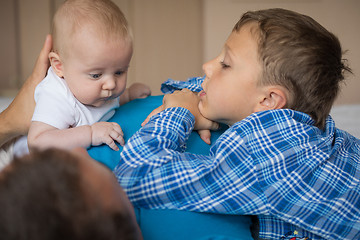 Image showing father and sons lie on the bed.