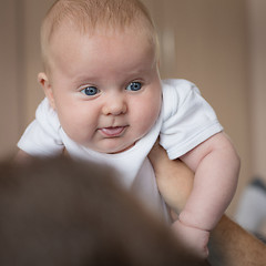 Image showing Father and baby son  playing on the bed.