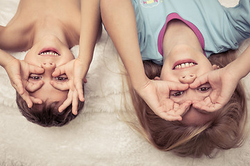 Image showing Lovely brother and sister lying in bed at home.