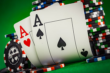 Image showing Stack of chips and two aces on the table on the green baize