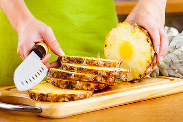 Image showing Woman\'s hands cutting pineapple