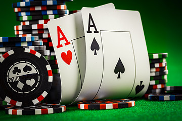 Image showing Stack of chips and two aces on the table on the green baize