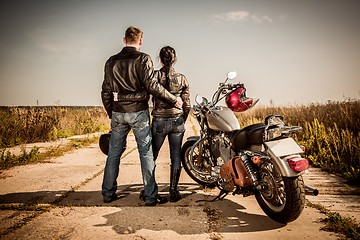 Image showing Biker man and girl stands on the road and looks into the distanc