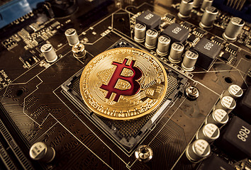 Image showing Gold Bit Coin BTC coins on the motherboard. Bitcoin is a worldwi