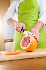 Image showing Woman\'s hands cutting grapefruit