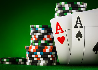 Image showing Stack of chips and two aces on the table on the green baize