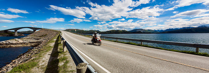 Image showing Biker rides a road with Atlantic Ocean Road in Norway.