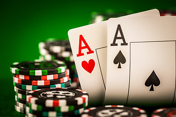 Image showing Stack of chips and two aces on the table on the green baize