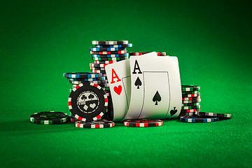 Image showing Stack of chips and two aces on the table on the green baize