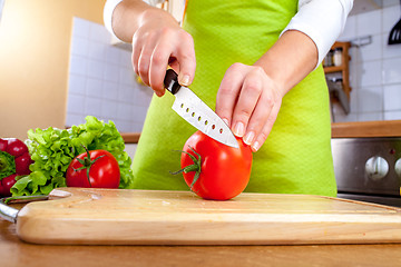 Image showing Woman\'s hands cutting tomato