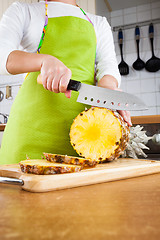 Image showing Woman\'s hands cutting pineapple