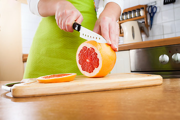 Image showing Woman\'s hands cutting grapefruit