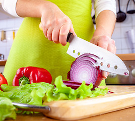 Image showing Woman\'s hands cutting bulb onion