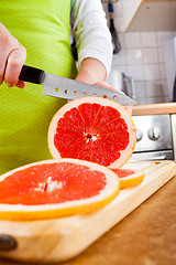 Image showing Woman\'s hands cutting grapefruit