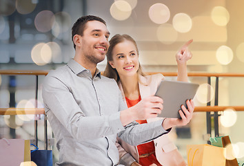 Image showing couple with tablet pc and shopping bags in mall