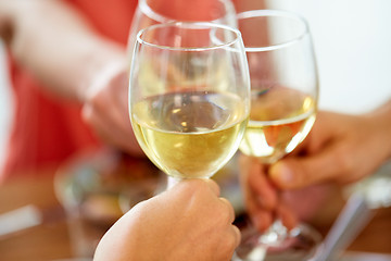 Image showing close up of hands clinking wine glasses