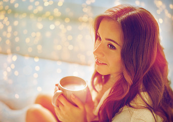 Image showing happy woman with cup of cocoa in bed at home