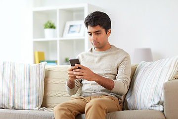 Image showing man with smartphone at home