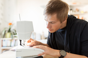 Image showing fashion designer with sewing machine at studio