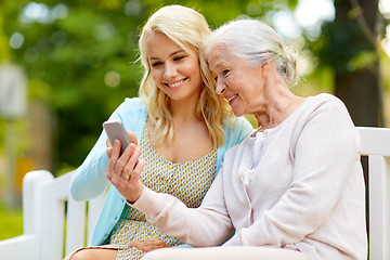 Image showing daughter and senior mother with smartphone at park