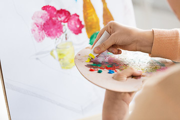 Image showing artist applying paint to palette at art studio