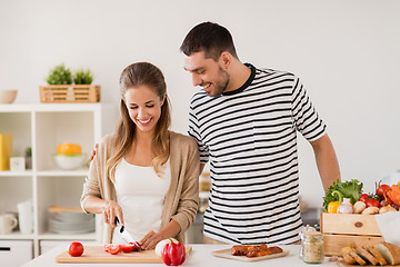 Image showing happy couple cooking food at home kitchen