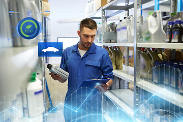 Image showing auto mechanic with oil and clipboard at car shop