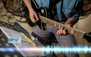 Image showing man with music book on stand playing guitar