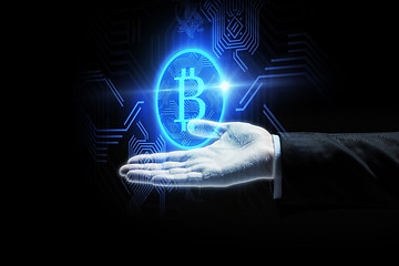 Image showing close up of businessman hand with bitcoin symbol