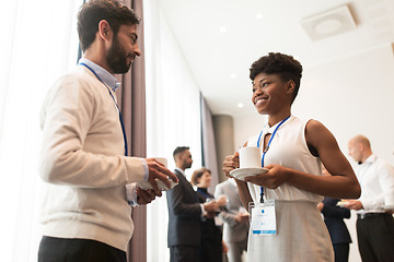 Image showing business people with conference badges and coffee