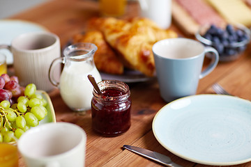 Image showing jar with jam on wooden table at breakfast