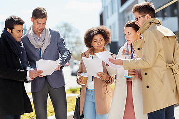 Image showing international business team with papers outdoors