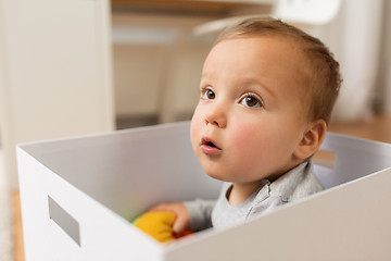 Image showing close up of sweet little baby boy in toy box