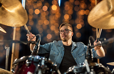 Image showing musician playing drum kit at concert over lights