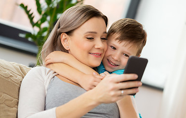 Image showing happy family with smartphone at home