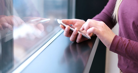 Image showing Elegant Woman Using Mobile Phone by window in office building