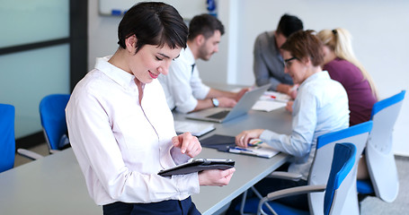 Image showing Businesswoman using tablet with coworkers in backgorund having m