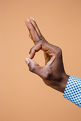 Image showing Hand showing OK sign isolated on brown background.