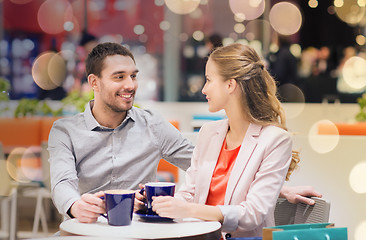 Image showing happy couple with shopping bags drinking coffee