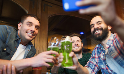 Image showing friends taking selfie with green beer at pub