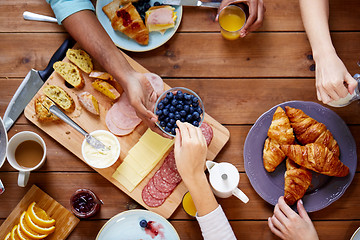 Image showing people having breakfast at table with food