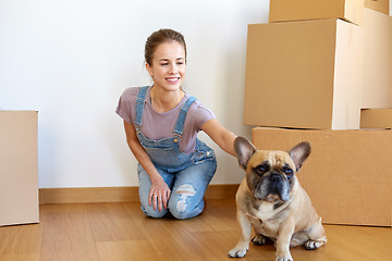 Image showing happy woman with dog and boxes moving to new home