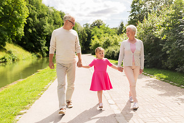 Image showing senior grandparents and granddaughter at park